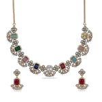 Display of an antique gold plated necklace with navartna gemstones and matching stud earrings.