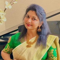A middle aged woman in green and yellow saree wearing pendant necklace