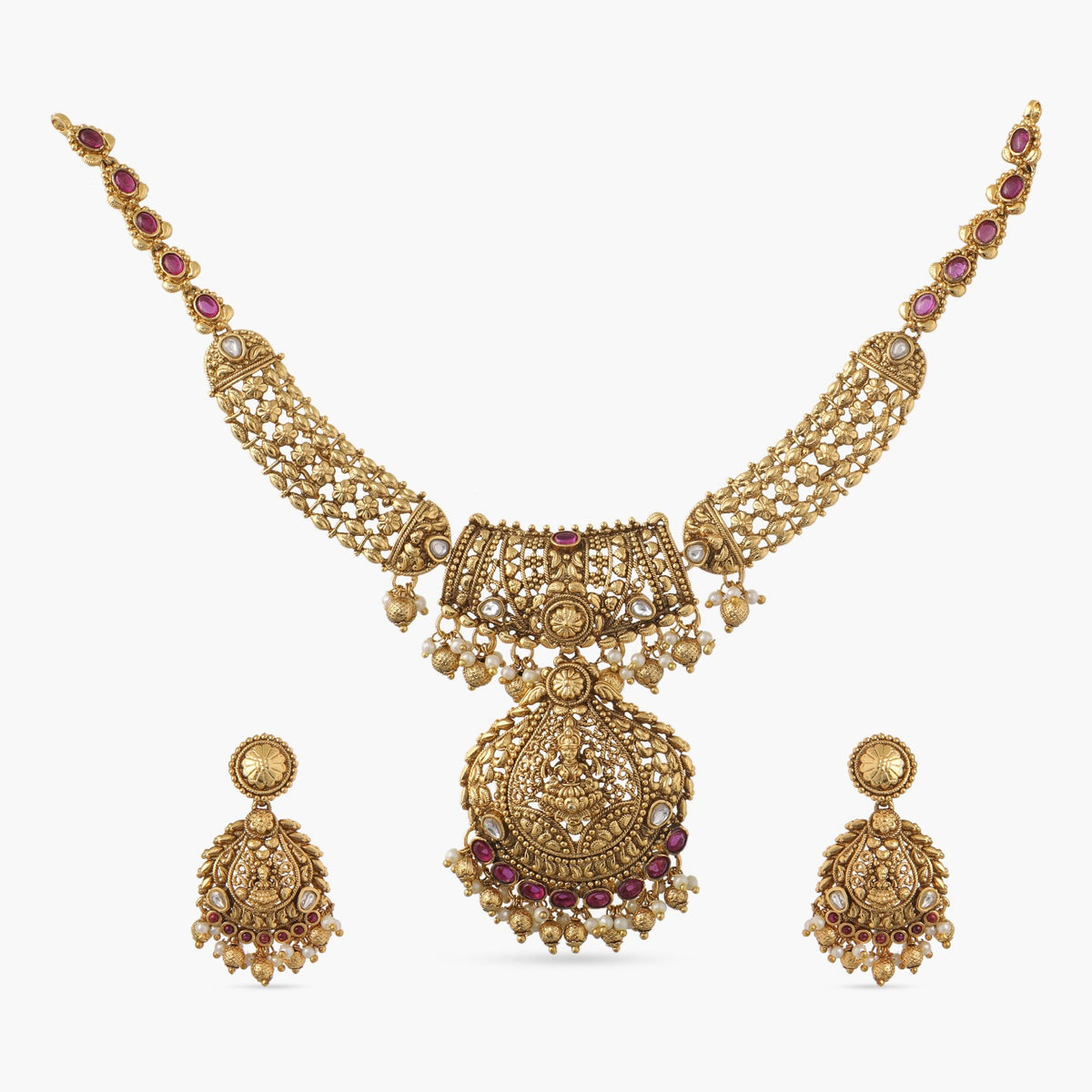 A picture of an Indian artificial gold plated necklace set with a pendant featuring Lakshmi design and red gemstones with matching earrings.