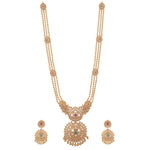 A picture of an Indian artificial necklace set with a gold-toned chain, a floral pendant with green gemstones, and matching earrings.
