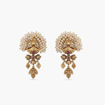 A picture of a pair of Indian antique gold plated earrings with a red gem and pearl details.