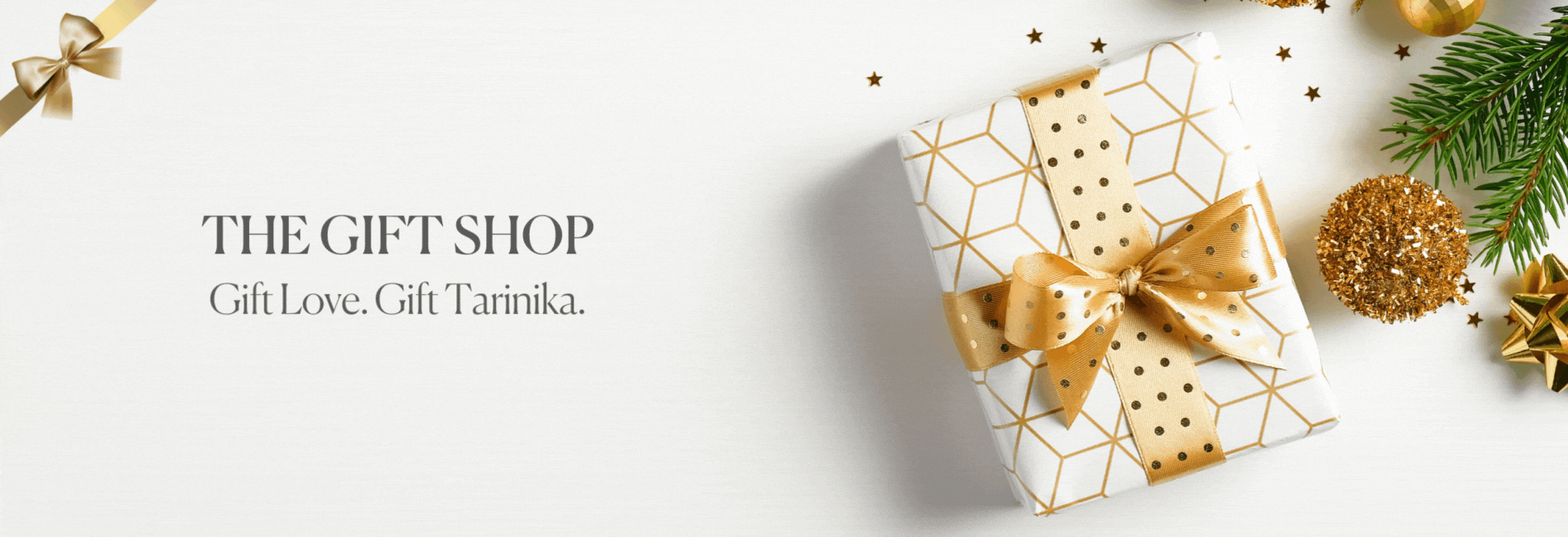 Image of gift wrapped with white paper and ribbon with text written: "The Gift Shop gift Love Gift Tarinika"
