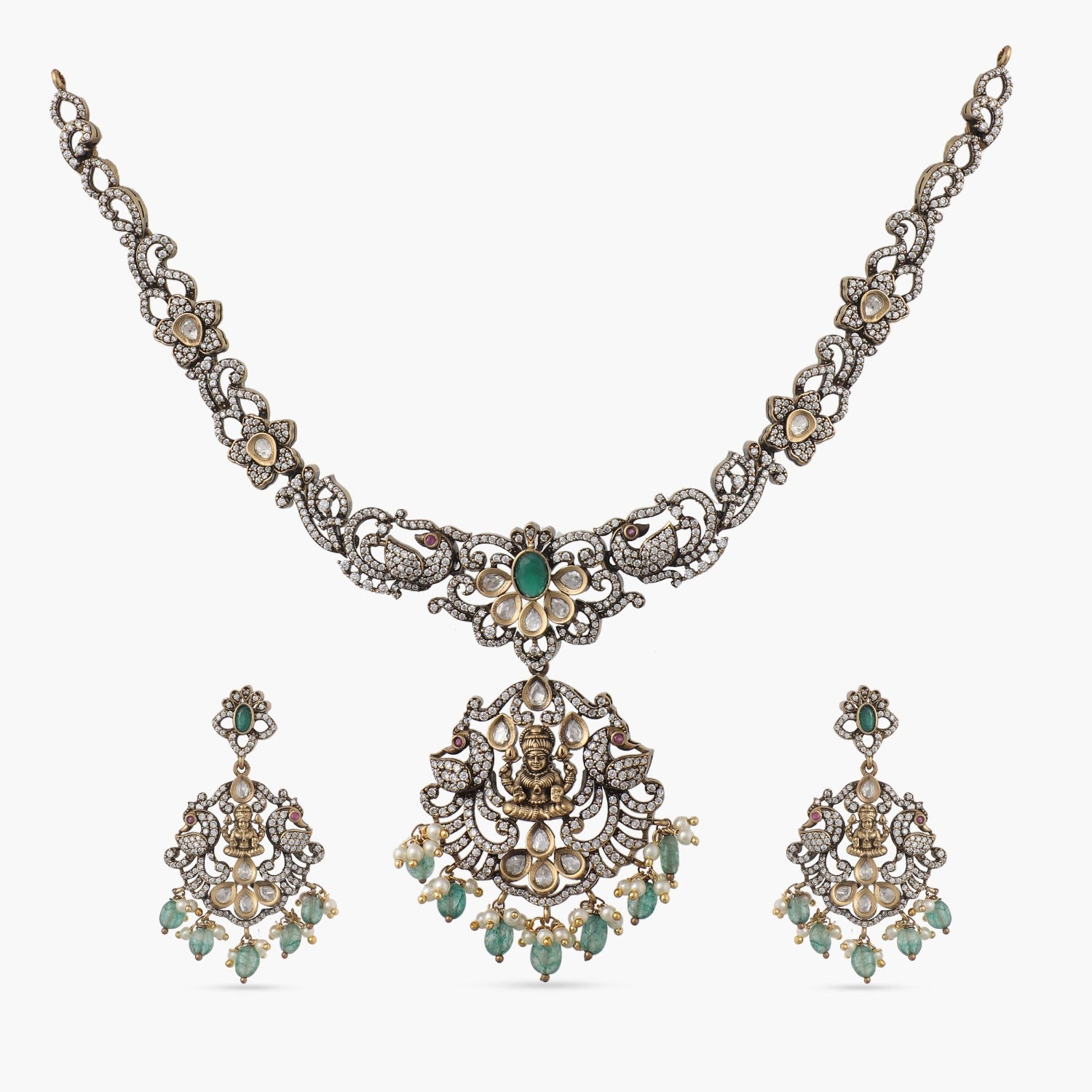 A picture of an Indian artificial gold plated necklace set with floral designs,Cubic Zirconia and red gemstones , and pearl embellishments.