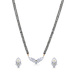 A close up picture of a necklace set, featuring white, black and green beads with a pendant.