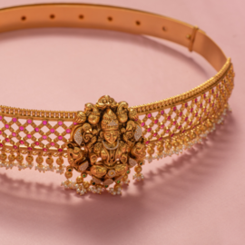 antique waist band on pink surface