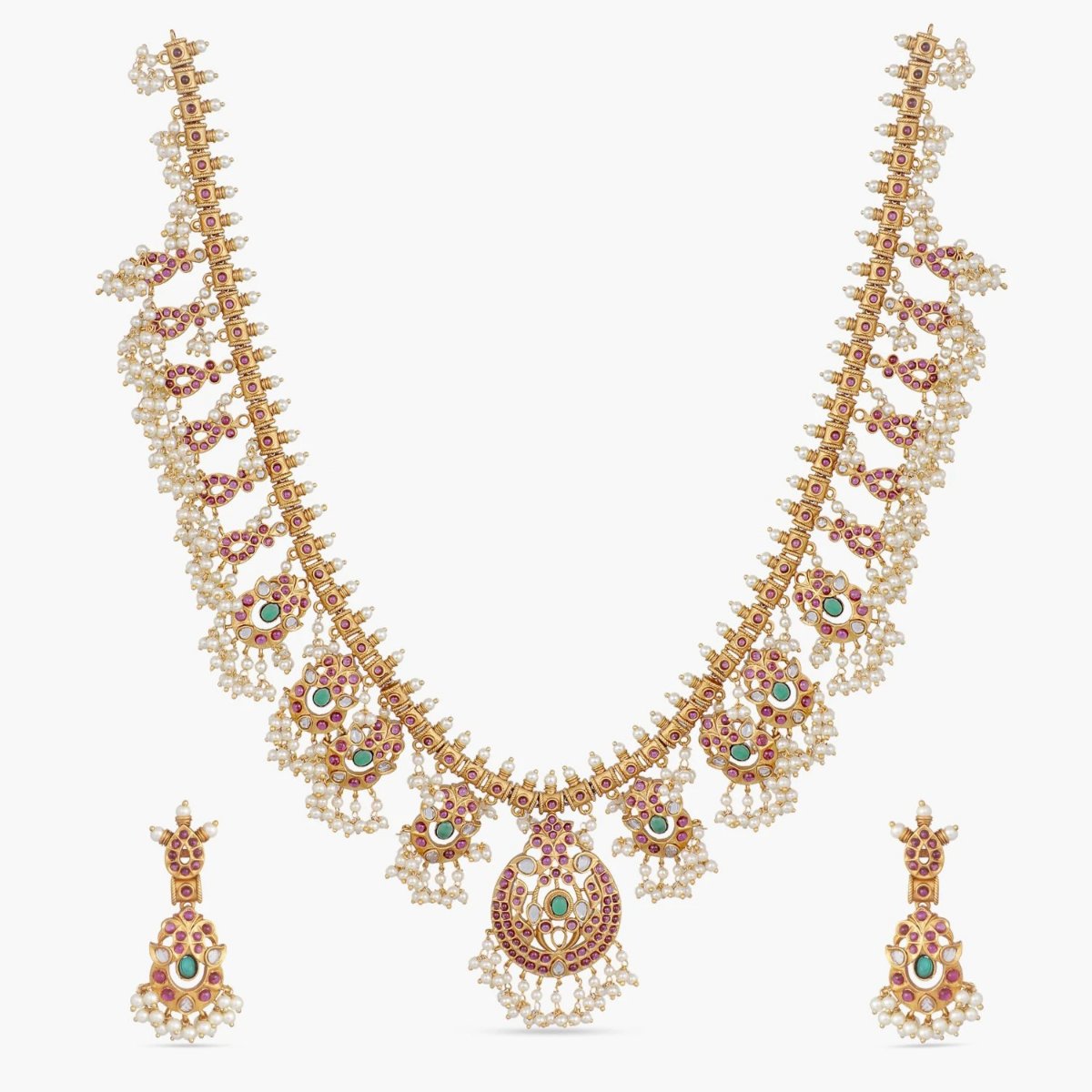 A picture of an Indian artificial necklace set with a gold-toned chain and a large pendant with floral designs. The pendant has red and green gemstones.