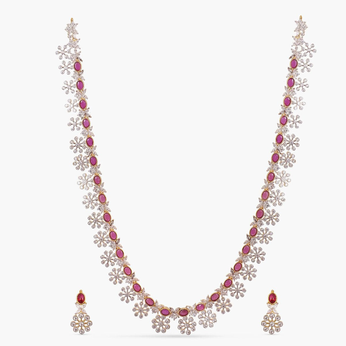A picture of an Indian artificial necklace and earring set, featuring a gold plated necklace with red gemstones and Cubic Zirconia